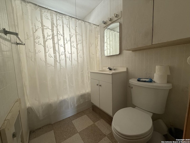 318 Uvalde, San Antonio, TX 78210 - full bathroom featuring toilet, vanity, shower / tub combo with curtain, and tile walls