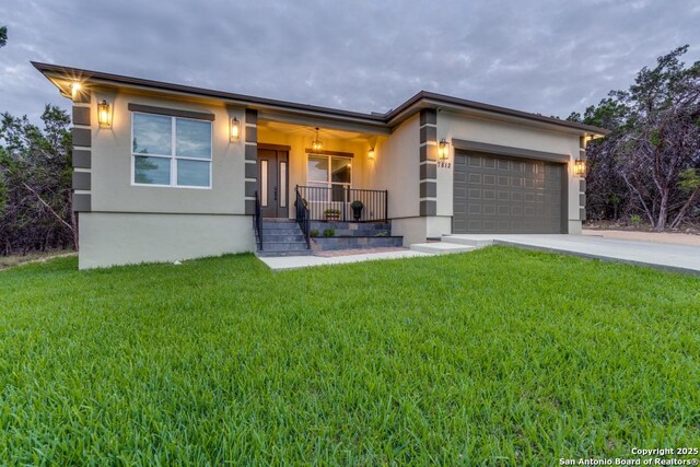 7812 Ventura Blvd, Selma, TX 78154 - view of front facade featuring covered porch, stucco siding, a front yard, an attached garage, and concrete driveway