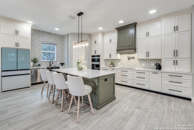 7812 Ventura Blvd, Selma, TX 78154 - kitchen featuring appliances with stainless steel finishes, light countertops, tasteful backsplash, light wood finished floors, and a kitchen bar