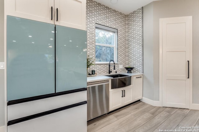 7812 Ventura Blvd, Selma, TX 78154 - kitchen with white refrigerator, stainless steel dishwasher, a sink, light wood finished floors, and white cabinetry