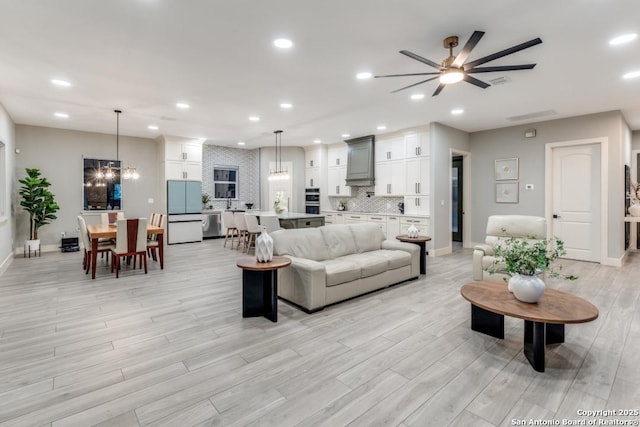 7812 Ventura Blvd, Selma, TX 78154 - living area featuring ceiling fan, light wood-style flooring, baseboards, recessed lighting, and a chandelier