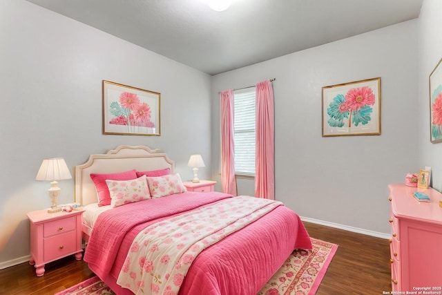 bedroom with dark wood finished floors and baseboards