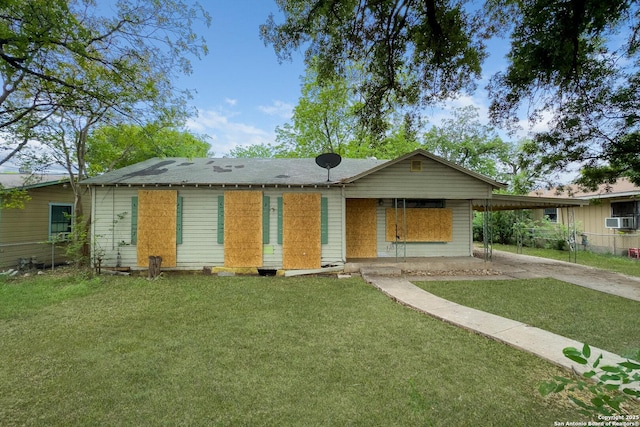 back of property featuring driveway, a carport, and cooling unit