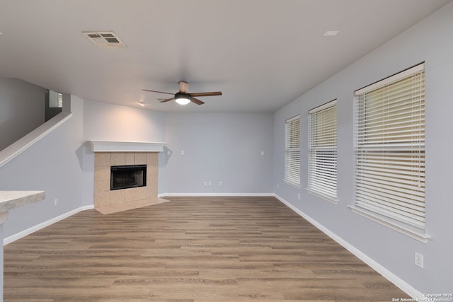 7603 Braun Bnd, San Antonio, TX 78250 - unfurnished living room with ceiling fan, a fireplace, wood finished floors, and baseboards