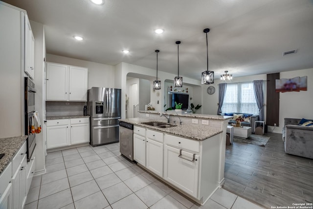 15323 Danae Bnd, San Antonio, TX 78245 - kitchen with appliances with stainless steel finishes, open floor plan, a sink, arched walkways, and recessed lighting