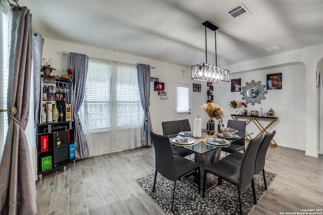 15323 Danae Bnd, San Antonio, TX 78245 - dining space with light wood-style flooring, a chandelier, and arched walkways