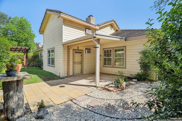 back of house with a chimney and a patio area
