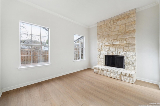 unfurnished living room featuring ornamental molding, wood finished floors, a stone fireplace, and baseboards