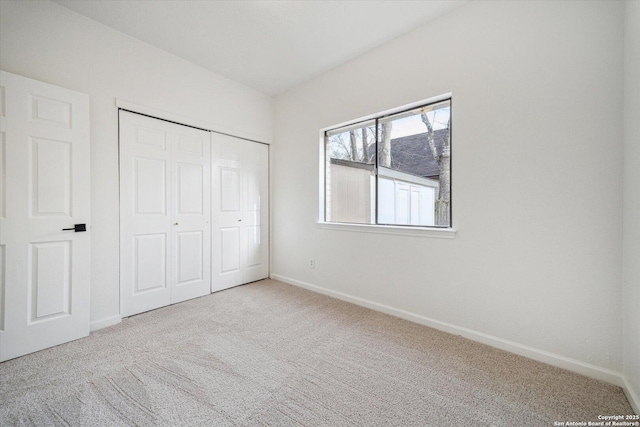 unfurnished bedroom with carpet floors, baseboards, and a closet