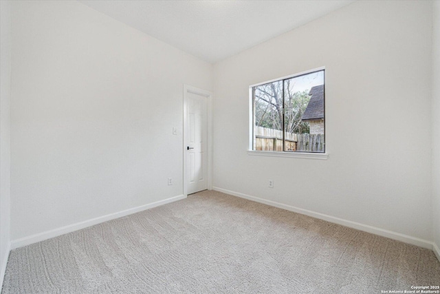 carpeted empty room with baseboards