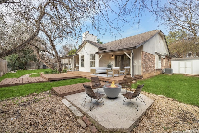 back of house featuring french doors, a deck, a storage unit, and a chimney