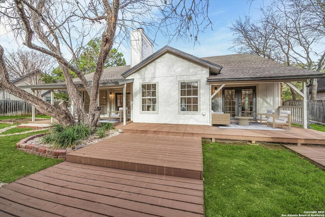 back of house featuring french doors, roof with shingles, a chimney, stucco siding, and a wooden deck