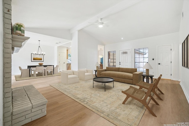 living area featuring wood finished floors, ceiling fan, and a chandelier