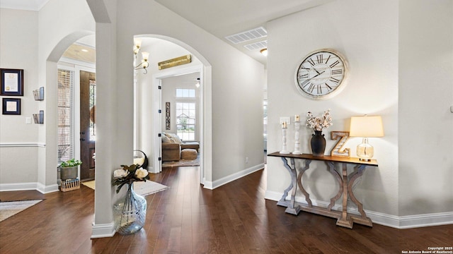 entrance foyer with arched walkways, wood finished floors, and baseboards