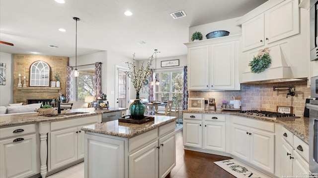 kitchen with a sink, healthy amount of natural light, tasteful backsplash, recessed lighting, and a kitchen island
