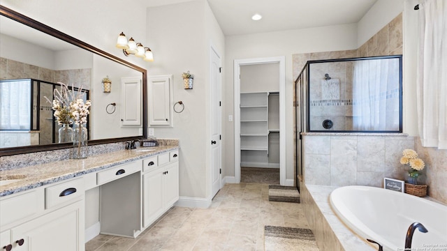 full bathroom featuring a stall shower, a garden tub, double vanity, and baseboards