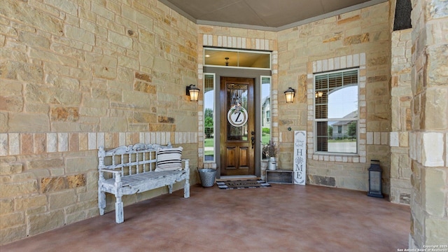 entrance to property featuring stone siding and a porch