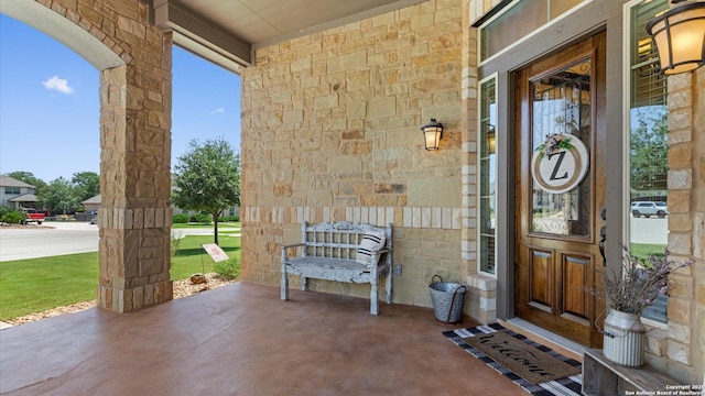 entrance to property featuring stone siding and a porch