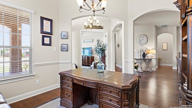 office area featuring a chandelier, arched walkways, dark wood-style flooring, and baseboards