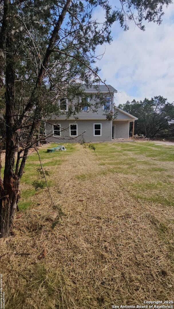 back of property with a lawn