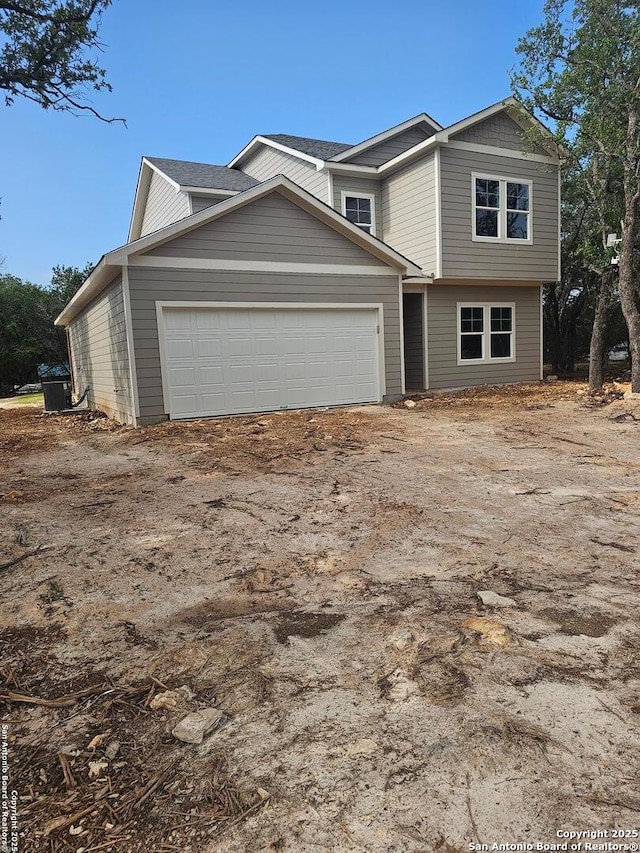 view of front of home featuring central AC unit and an attached garage