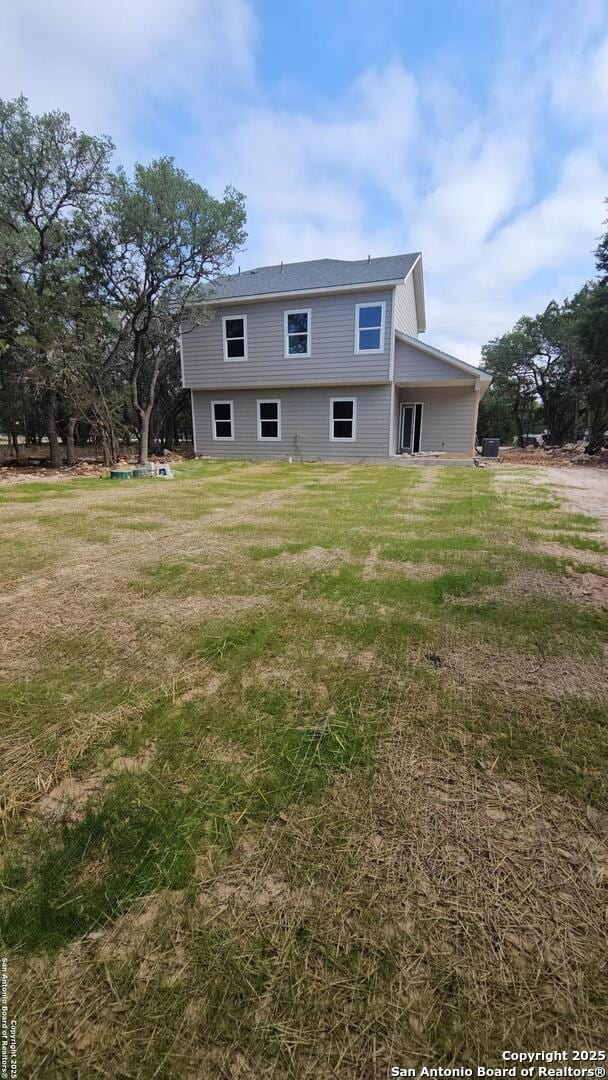 rear view of house featuring a yard
