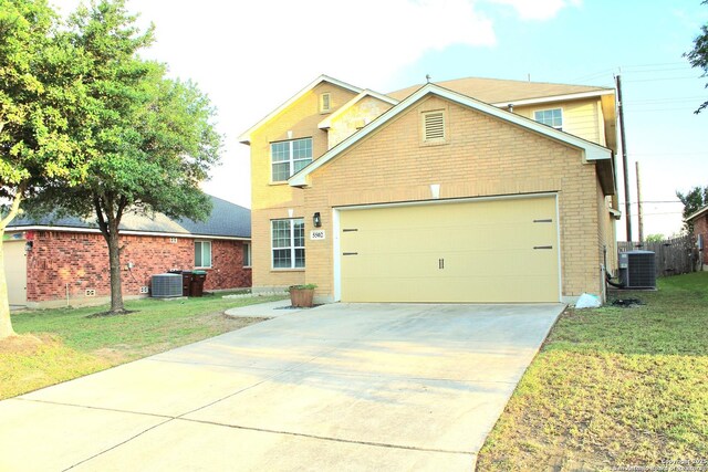 traditional-style home featuring central air condition unit, a front yard, brick siding, a garage, and driveway