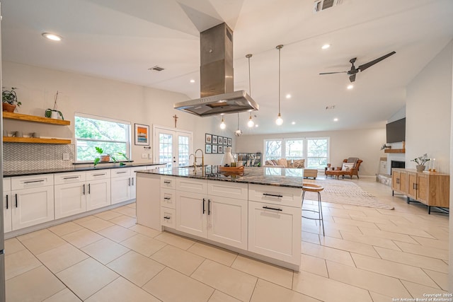 kitchen with island range hood, french doors, healthy amount of natural light, ceiling fan, and recessed lighting