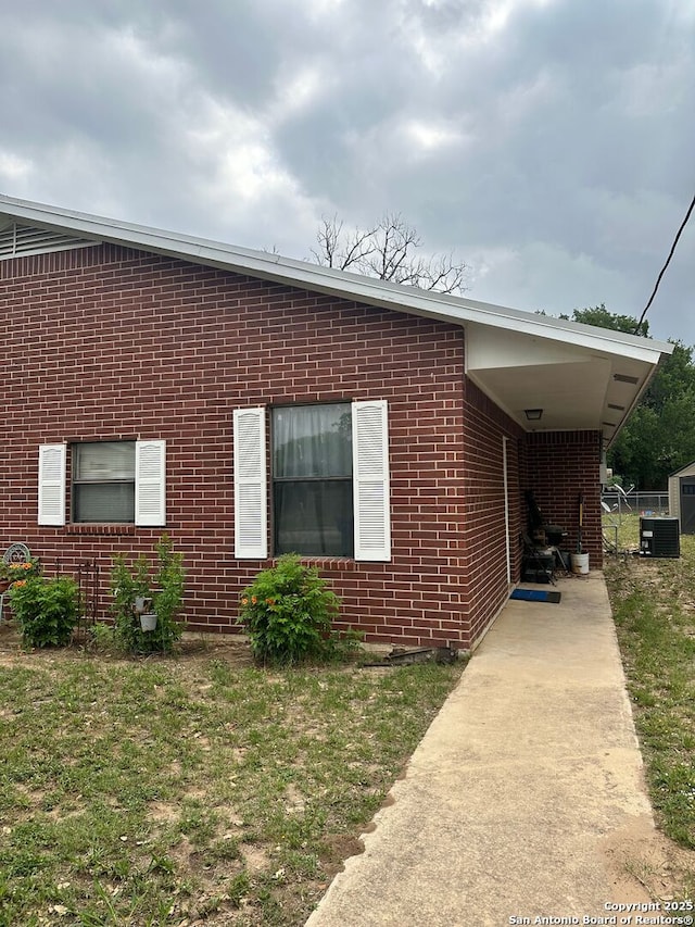 1005-03 Commerce, Pleasanton, TX 78064 - view of property exterior featuring brick siding and central AC
