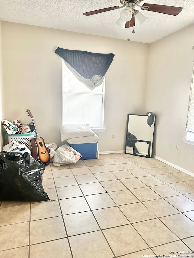 401/403 W Adams, Pleasanton, TX 78064 - spare room with a ceiling fan, a textured ceiling, light tile patterned flooring, and healthy amount of natural light