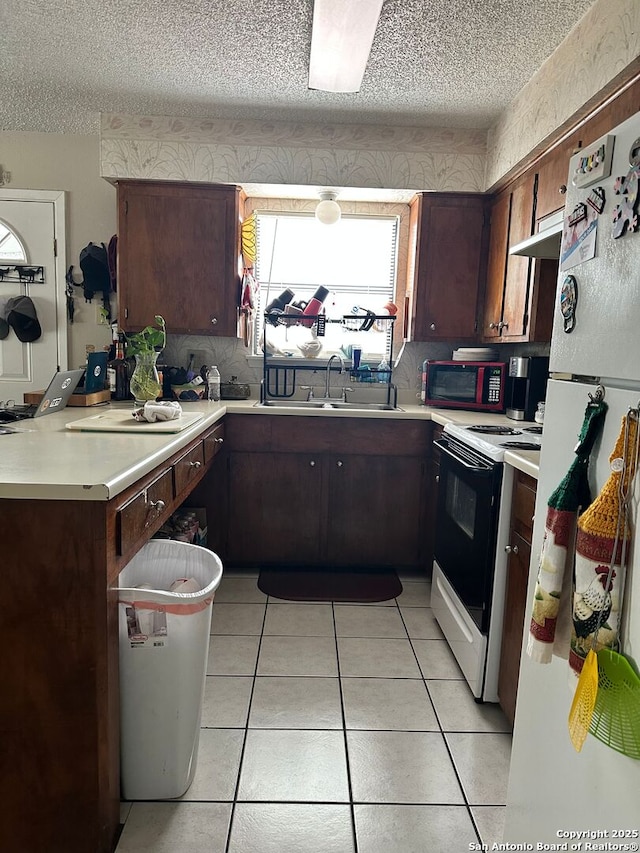 401/403 W Adams, Pleasanton, TX 78064 - kitchen featuring electric stove, a sink, freestanding refrigerator, a textured ceiling, and light countertops