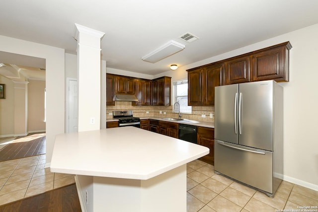 kitchen featuring stainless steel appliances, ornate columns, under cabinet range hood, and light tile patterned floors