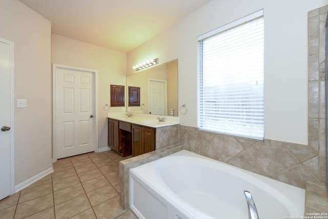 bathroom featuring healthy amount of natural light, a bath, tile patterned flooring, and double vanity