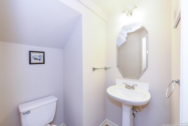 half bath with toilet and vaulted ceiling