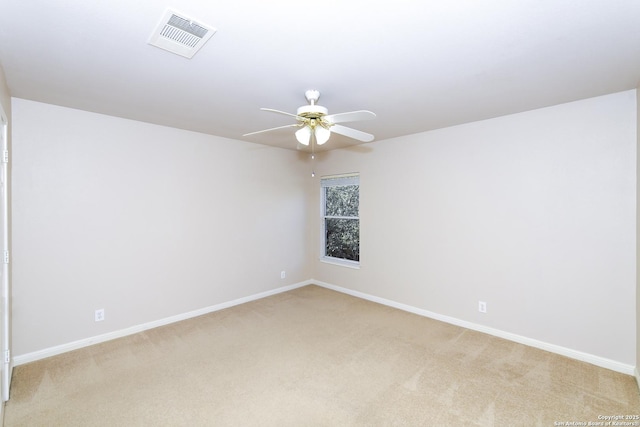 spare room with light carpet, a ceiling fan, and baseboards