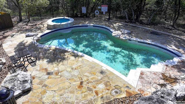 view of pool with a hot tub, fence, and a patio area