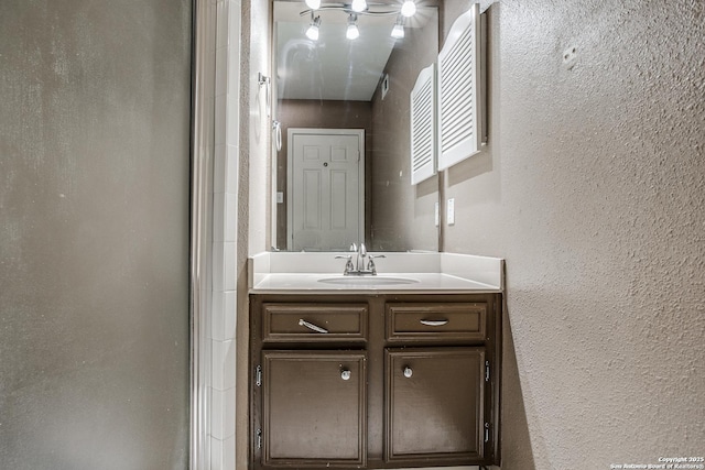 7930 Roanoke Unit 106, San Antonio, TX 78240 - bathroom featuring a textured wall, vanity, and a stall shower