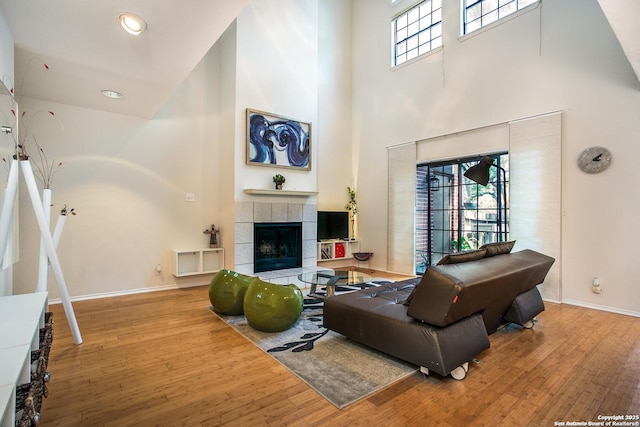 7930 Roanoke Unit 106, San Antonio, TX 78240 - living area with a towering ceiling, a fireplace, wood finished floors, and baseboards