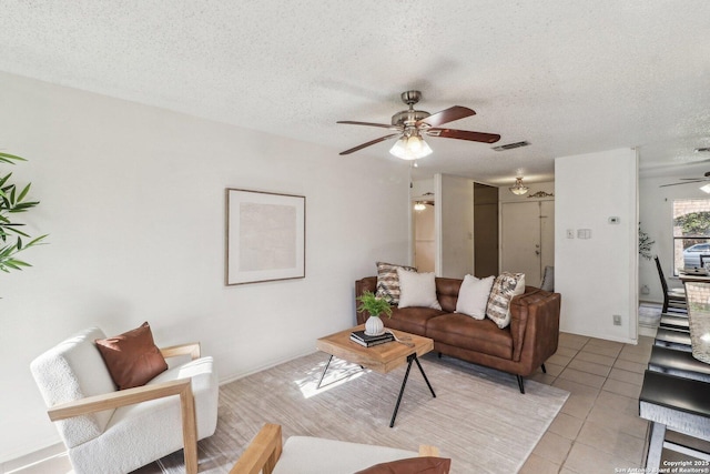 11731 Spring Rain, San Antonio, TX 78249 - living area with a ceiling fan, a textured ceiling, and light tile patterned floors