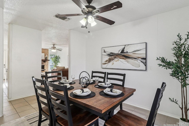 11731 Spring Rain, San Antonio, TX 78249 - dining room with a ceiling fan, a textured ceiling, light tile patterned floors, and baseboards