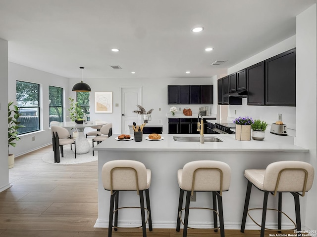 15827 Marisa, San Antonio, TX 78247 - kitchen with a sink, a peninsula, a breakfast bar area, recessed lighting, and dark cabinetry