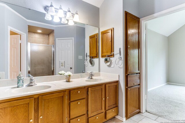 bathroom featuring a stall shower, tile patterned flooring, double vanity, and baseboards
