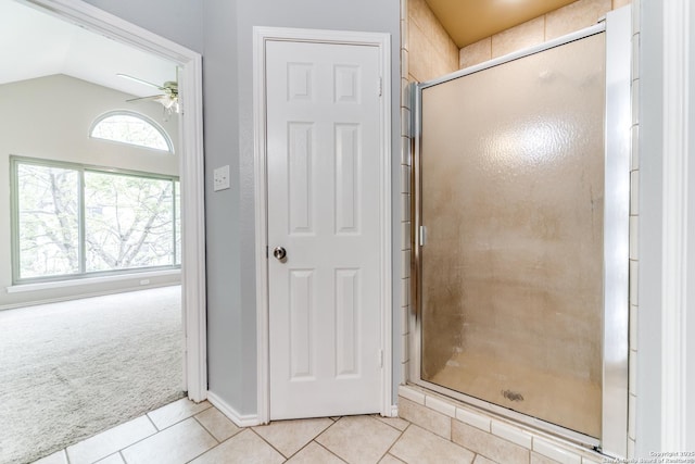 full bath with tile patterned floors, a ceiling fan, a stall shower, lofted ceiling, and baseboards