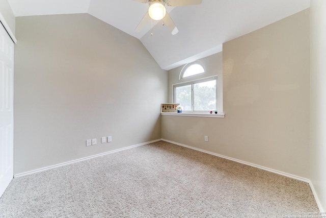 carpeted empty room with a ceiling fan, lofted ceiling, and baseboards