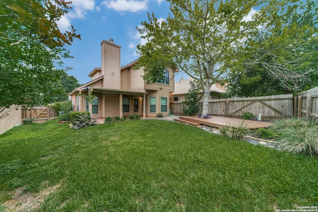 rear view of property with a chimney and a deck