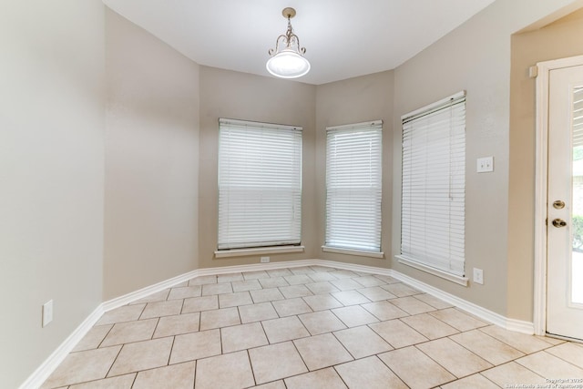 spare room with healthy amount of natural light and baseboards