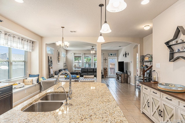 12338 Belfort Pt, Schertz, TX 78154 - kitchen featuring arched walkways, a sink, a ceiling fan, light tile patterned flooring, and hanging light fixtures