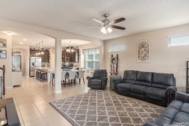 12338 Belfort Pt, Schertz, TX 78154 - living room with arched walkways, light tile patterned flooring, ceiling fan, and plenty of natural light
