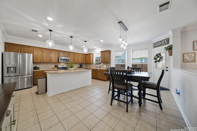 kitchen with stainless steel appliances, ornamental molding, light countertops, decorative backsplash, and light tile patterned flooring
