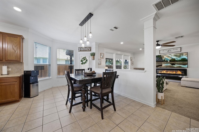 dining space featuring light tile patterned floors, healthy amount of natural light, crown molding, baseboards, and ceiling fan